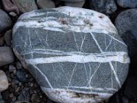 Grauer Stein mit kräftigen und filigranen weißen Streifen